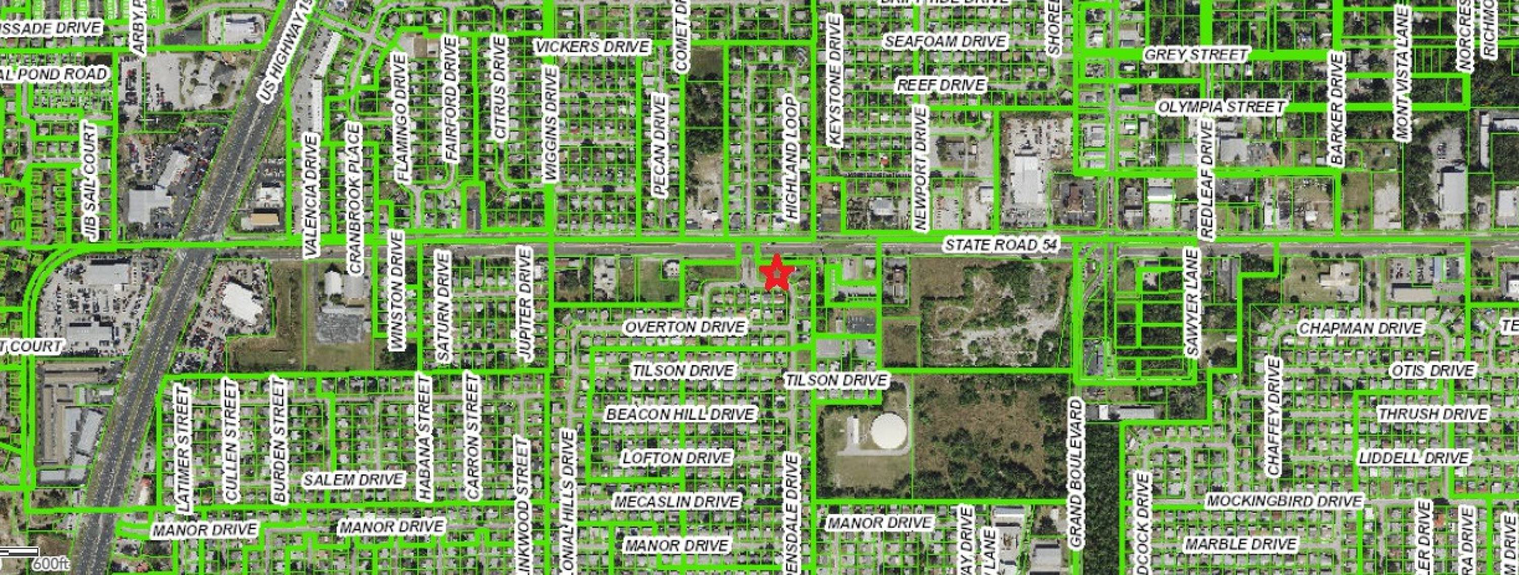 A clear drone shot displaying the vacant C2 zoned commercial land for development, highlighting its prime location and visibility on State Road 54.