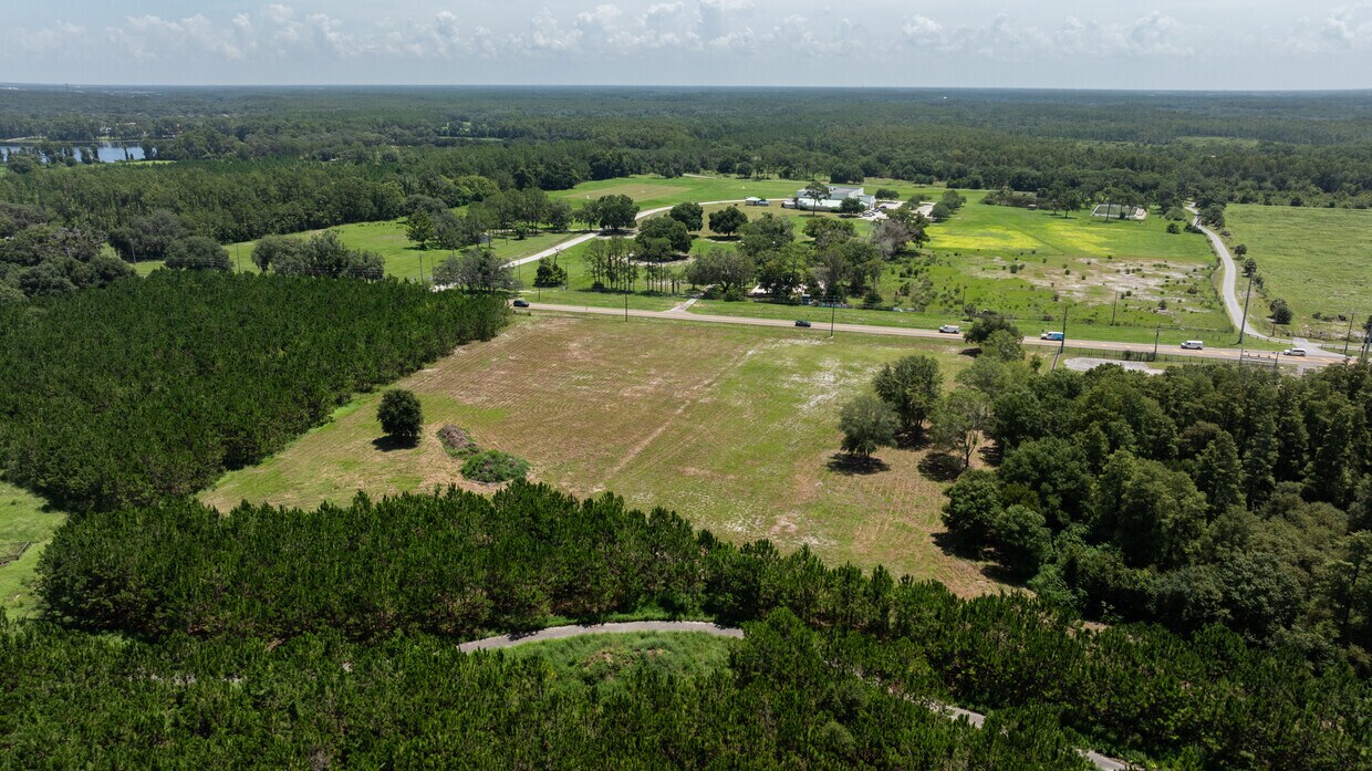 Elevated View of Development Land An elevated view of the expansive 4.7-acre parcel, highlighting the mix of cleared land and surrounding pine trees.