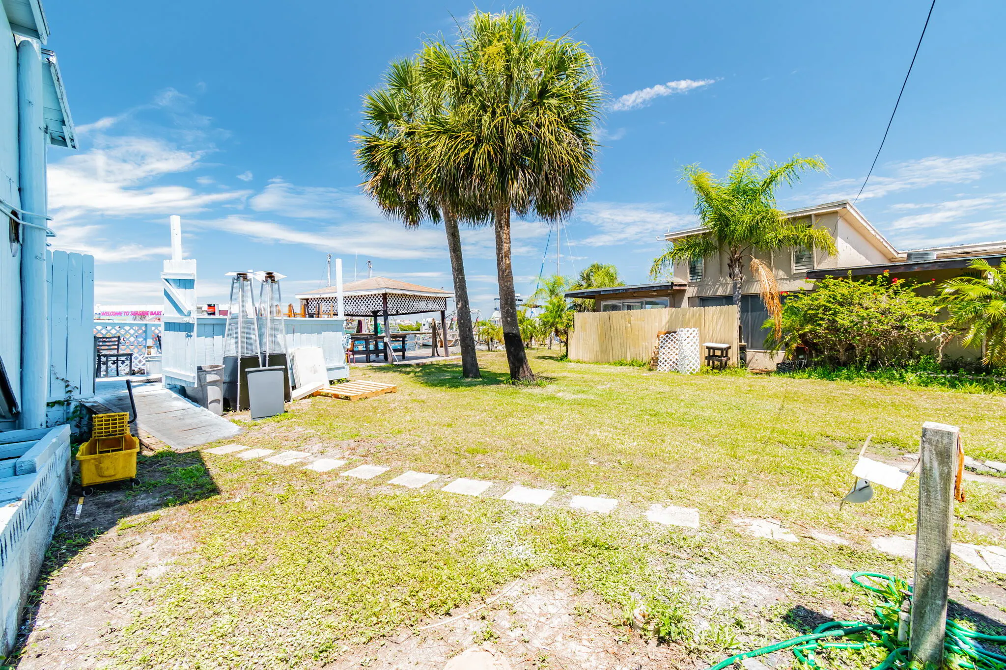 A view from the grassy backyard of the property looking towards the harbor, showcasing the potential for outdoor amenities with direct Gulf access.